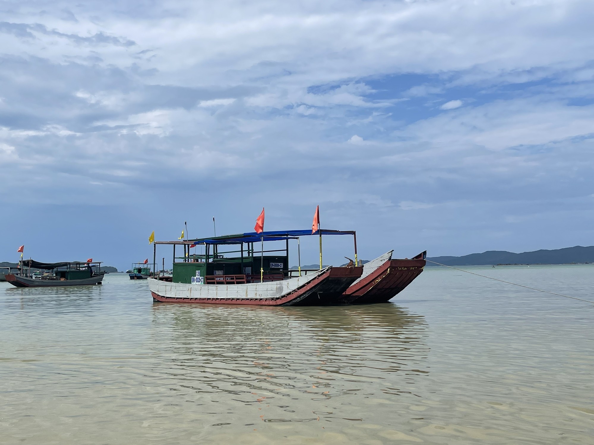 Phản chiếu với bầu trời màu xanh là làn nước trong vắt, những chiếc thuyền dừng ở đây để đón du khách ra tham quan đảo Cô Tô Con, hoặc các tour 3 đảo ngắm san hô, câu cá,...
