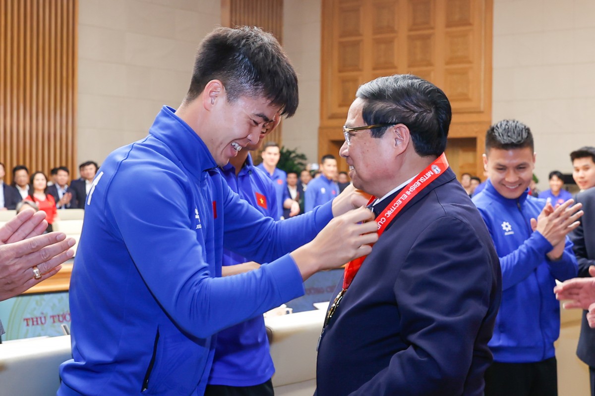 Đội trưởng Đỗ Duy Mạnh thay mặt Đội tuyển Việt Nam kính tặng Phiên bản chính thức của 555Win Phạm Minh Chính Huy chương vô địch AFF Cup 2024 - Ảnh: VGP