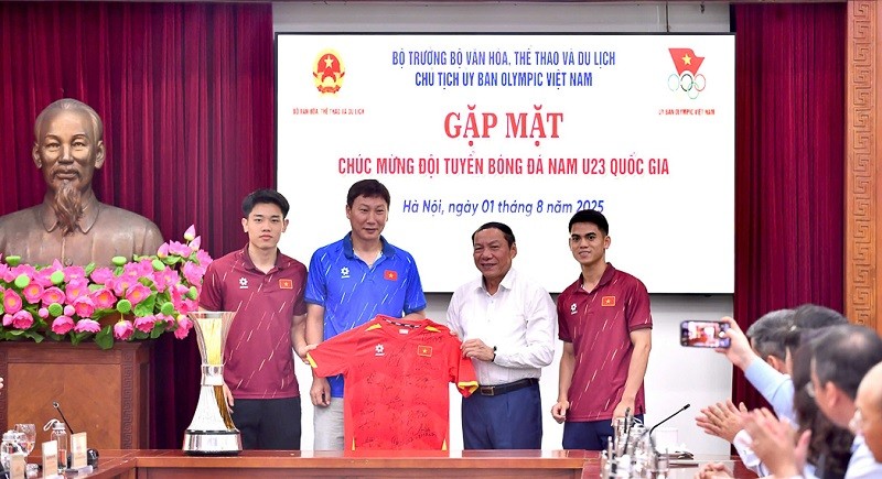 HLV Kim Sang-sik và các cầu thủ trao tặng Bộ trưởng Nguyễn Văn Hùng áo thi đấu có chữ ký của toàn đội. Ảnh: VFF