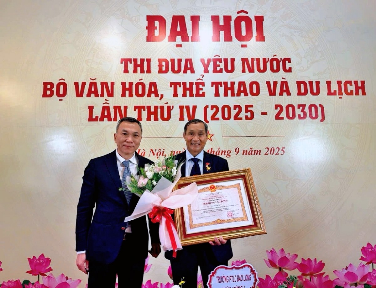 Chủ tịch Liên đoàn Bóng đá Việt Nam Trần Quốc Tuấn chúc mừng HLV Mai Đức Chung được trao danh hiệu Anh hùng Lao động. Ảnh: VFF