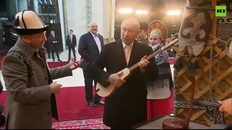 Ông Putin chơi thử nhạc cụ truyền thống của Kyrgyzstan. Ảnh: RT