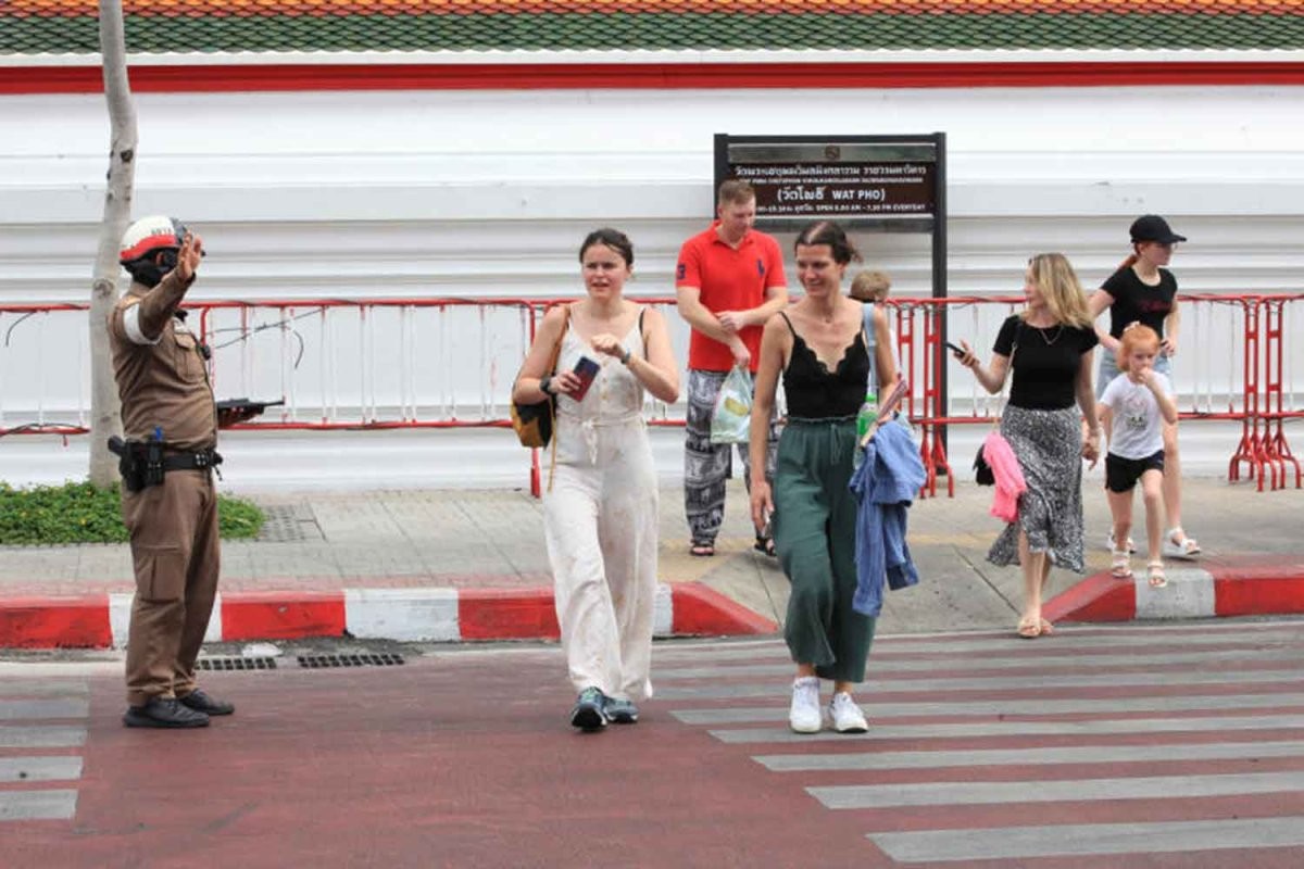 Một cảnh sát giao thông thuộc đồn cảnh sát Phra Ratchawang hỗ trợ đảm bảo an toàn cho du khách băng qua đường gần giao lộ Maharaj – Tha Tien. Ảnh: Bangkok Post