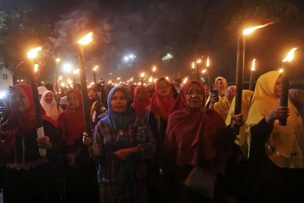 Phụ nữ Hồi gi&aacute;o cầm đuốc diễu h&agrave;nh trước khi bắt đầu th&aacute;ng lễ Ramadan ở Medan, Bắc Sumatra, Indonesia ng&agrave;y 18/3/2023. Ảnh: AP