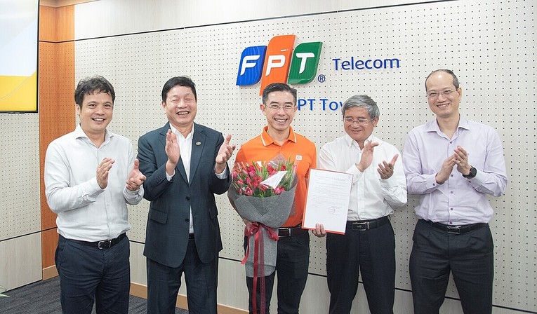 Ban l&atilde;nh đạo Tập đo&agrave;n FPT trao nghị quyết của HĐQT về việc bầu &ocirc;ng Ho&agrave;ng Việt Anh (giữa) l&agrave;m Chủ tịch FPT Telecom.