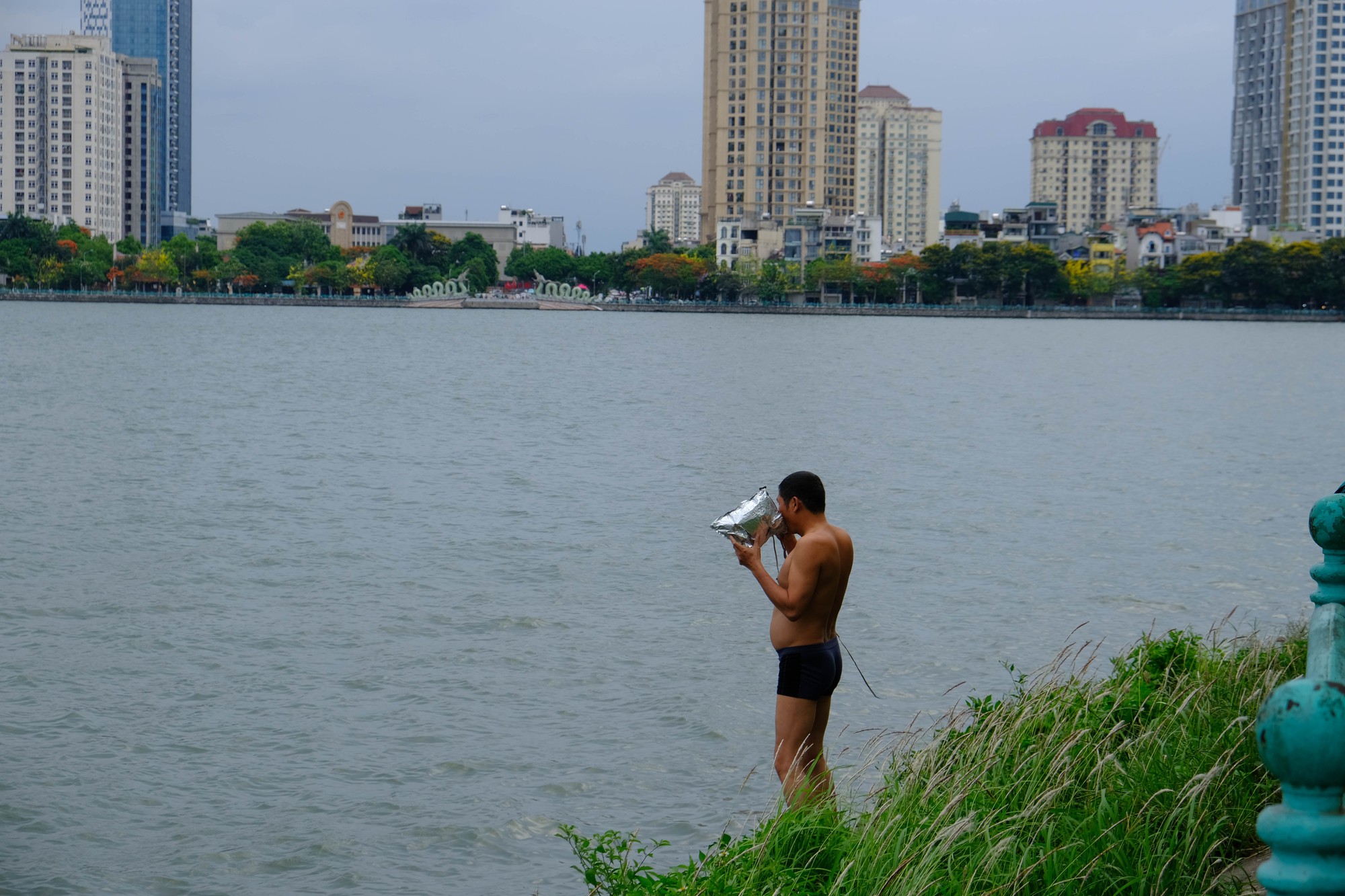 Những người bơi lội giải nhiệt tr&ecirc;n hồ T&acirc;y thường đeo k&iacute;nh bơi, trang bị những vật dụng th&ocirc; sơ như b&oacute;ng bay, b&igrave;nh nước rỗng để l&agrave;m phao. Ảnh: L&ecirc; An/555win Login.