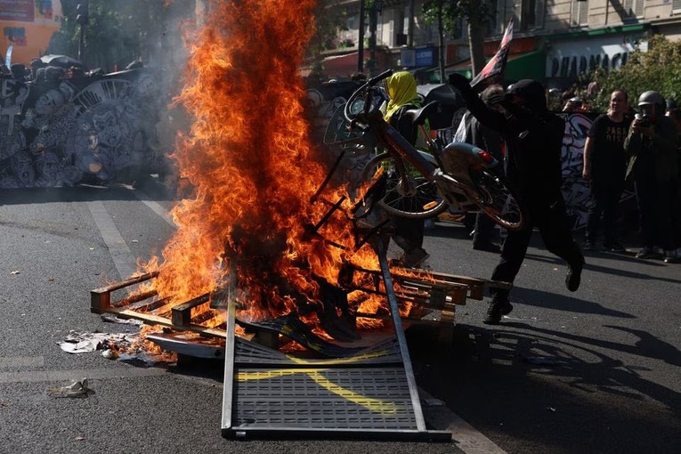 Người biểu t&igrave;nh đốt xe đạp tại Paris, Ph&aacute;p ng&agrave;y 6/6. Ảnh: Reuters