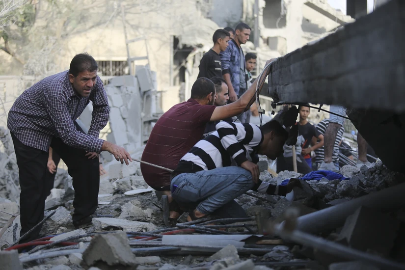 Người d&acirc;n Palestine t&igrave;m kiếm những người c&ograve;n sống s&oacute;t tại c&aacute;c đống đổ n&aacute;t sau cuộc kh&ocirc;ng k&iacute;ch của Israel v&agrave;o Rafah, Dải Gaza, ng&agrave;y 22/10. Ảnh: AP