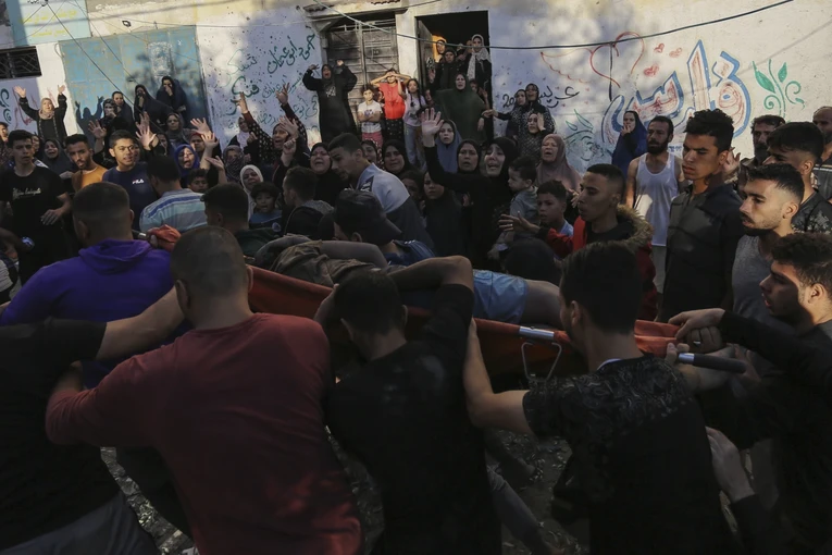 Người d&acirc;n đưa một thi thể nạn nh&acirc;n ra khỏi đống đổ n&aacute;t ở th&agrave;nh phố Gaza sau cuộc kh&ocirc;ng k&iacute;ch của Israel. Ảnh: AP