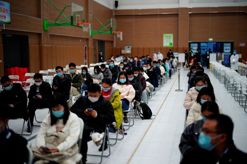 Người d&acirc;n Thượng Hải ngồi chờ sau khi được ti&ecirc;m ph&ograve;ng. Ảnh: Reuters