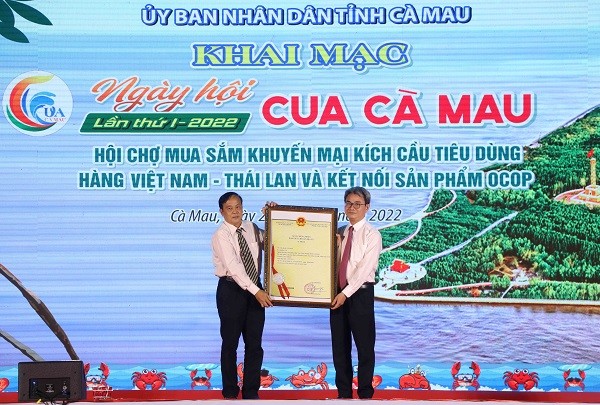 Cục trưởng Cục Sở hữu tr&iacute; tuệ Đinh Hữu Ph&iacute; (b&ecirc;n phải) trao giấy chứng nhận đăng k&yacute; chỉ dẫn địa l&yacute; sản phẩm cua C&agrave; Mau cho tỉnh C&agrave; Mau. Ảnh: CTTĐT tỉnh C&agrave; Mau