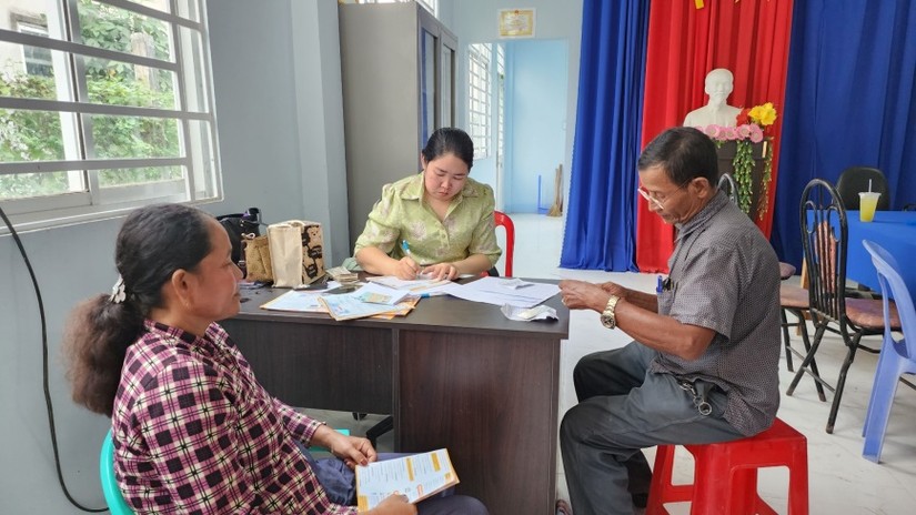Đồng b&agrave;o d&acirc;n tộc thiểu số Khmer tham gia mua bảo hiểm y tế tại điểm tuy&ecirc;n truyền. Ảnh: B&aacute;o An Giang